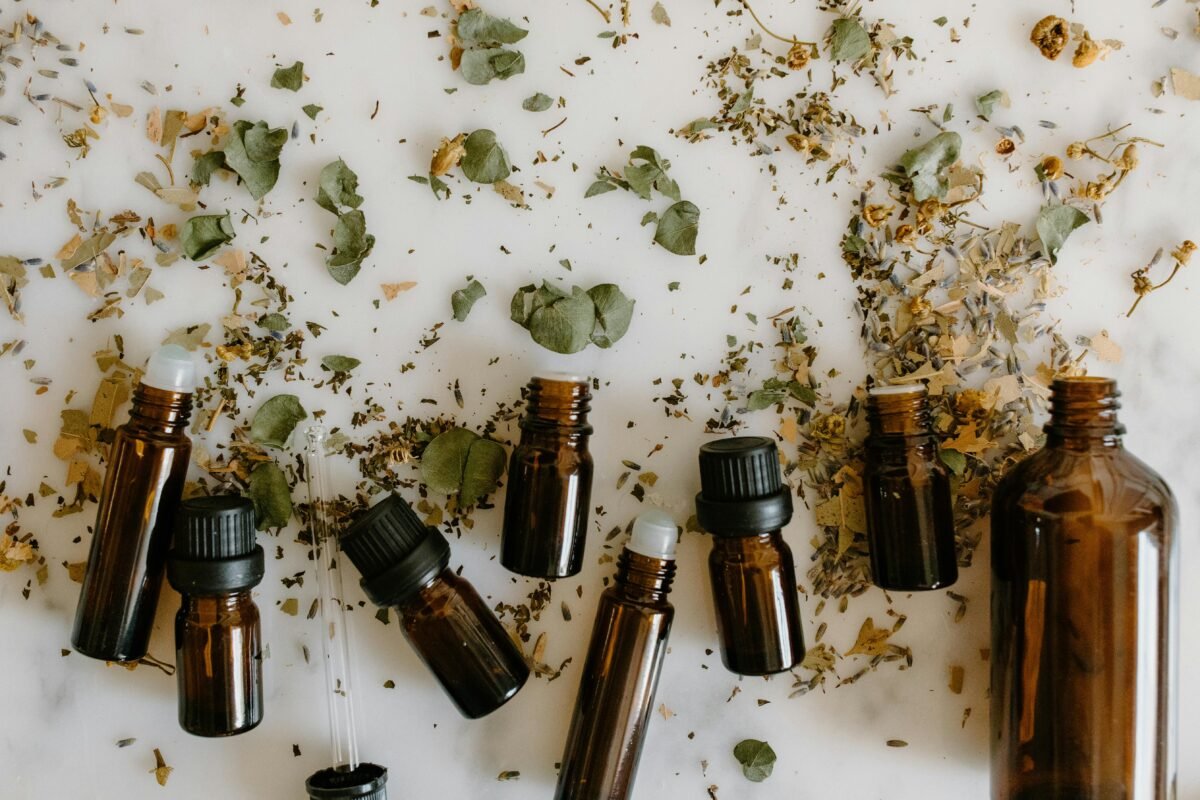 Flat lay of brown glass bottles and dried herbs, perfect for aromatherapy themes.